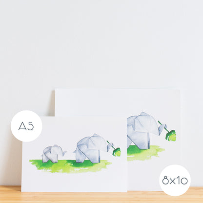 Watercolour painting art print. The watercolour illustration shows two painted origami elephants on green grass with one holding a monstera plant leaf.