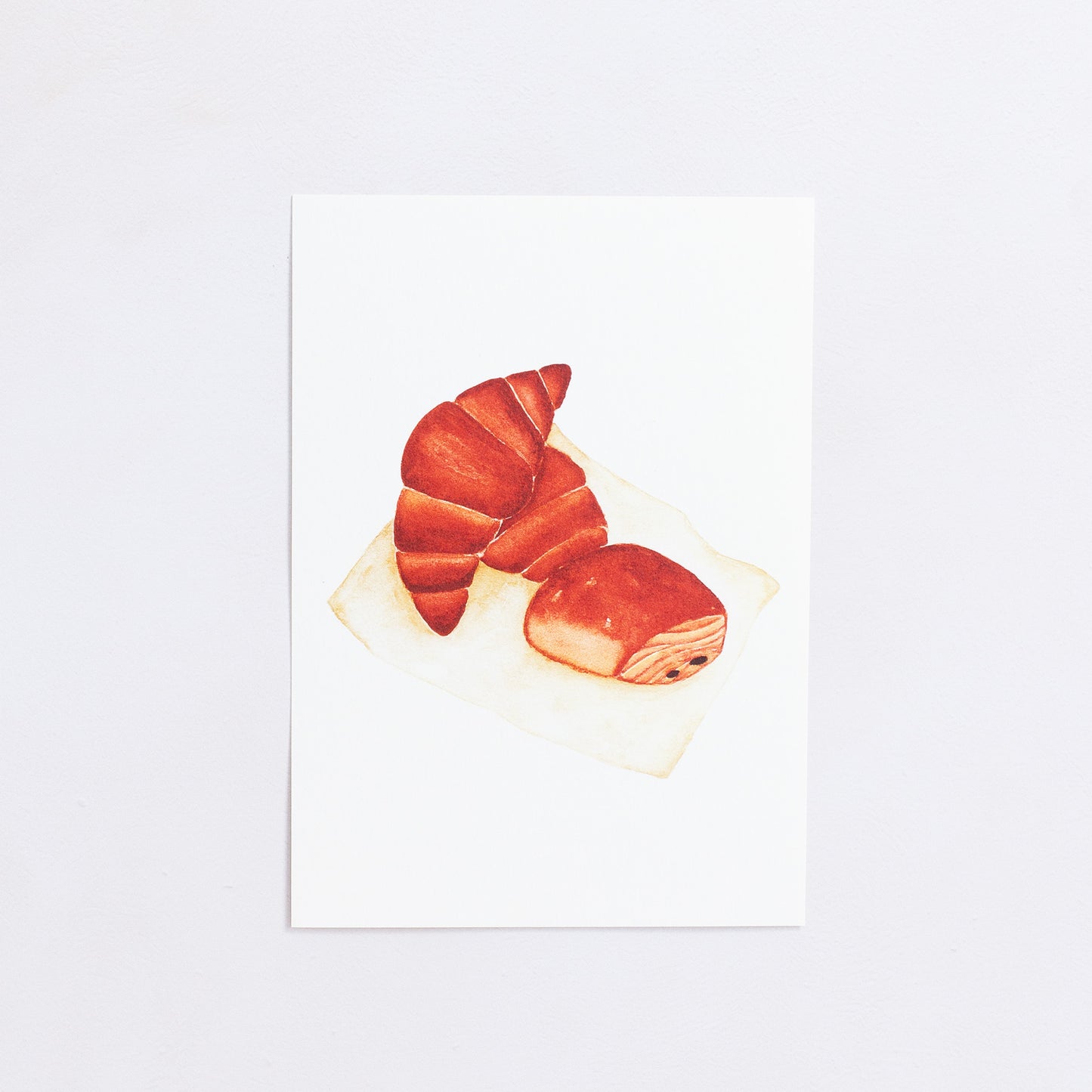 Watercolour colour art print. This watercolour illustration shows two croissants and a pain au chocolat.