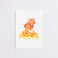 Watercolour painting art print. The watercolour illustration shows an origami autumn fox standing on top of a pile of autumn leaves.